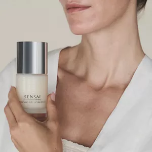 Close up of persons decolette area holding Cellular Performance Throat & Bust Lifting Effect in hand